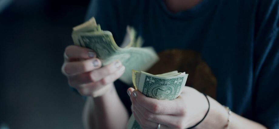 focus photography of person counting dollar banknotes